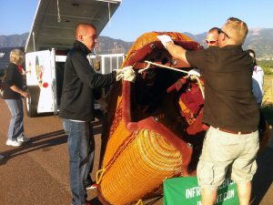 A ground crew loads up the hot air balloon basket into a trailer after flight